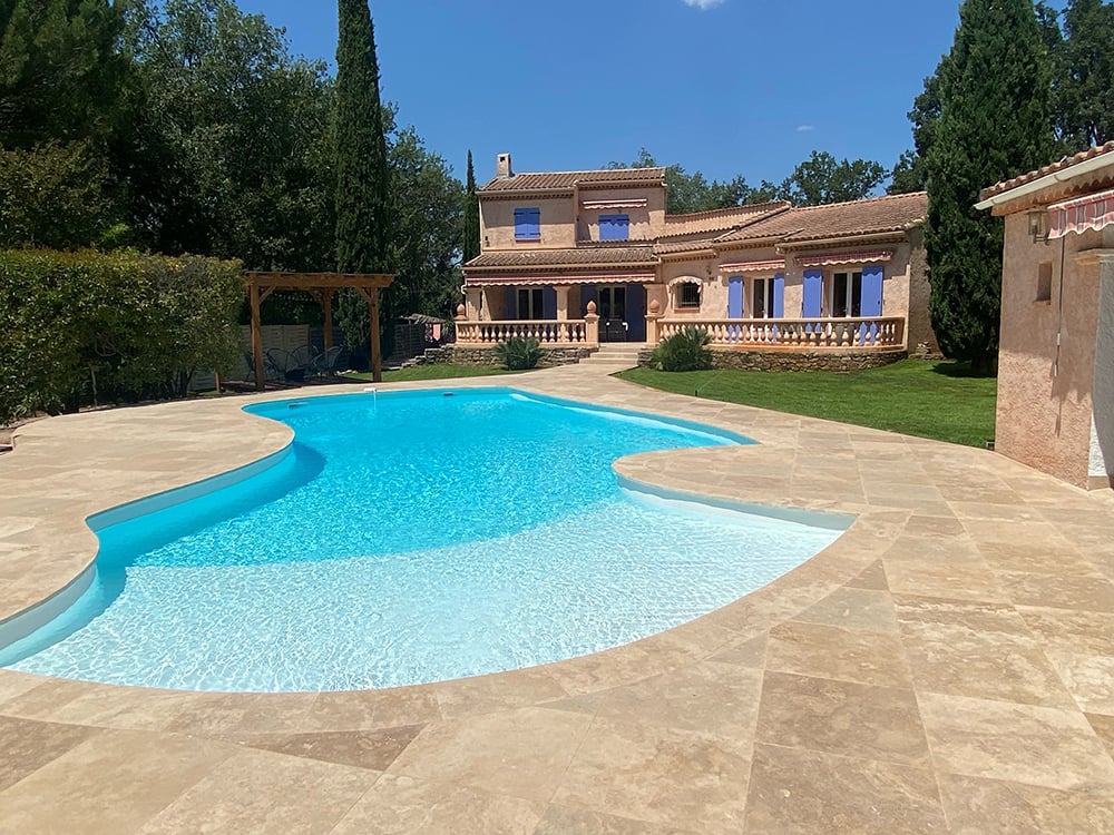 Technicien SOS Piscine Pro en intervention près d'une piscine moderne au crépuscule.